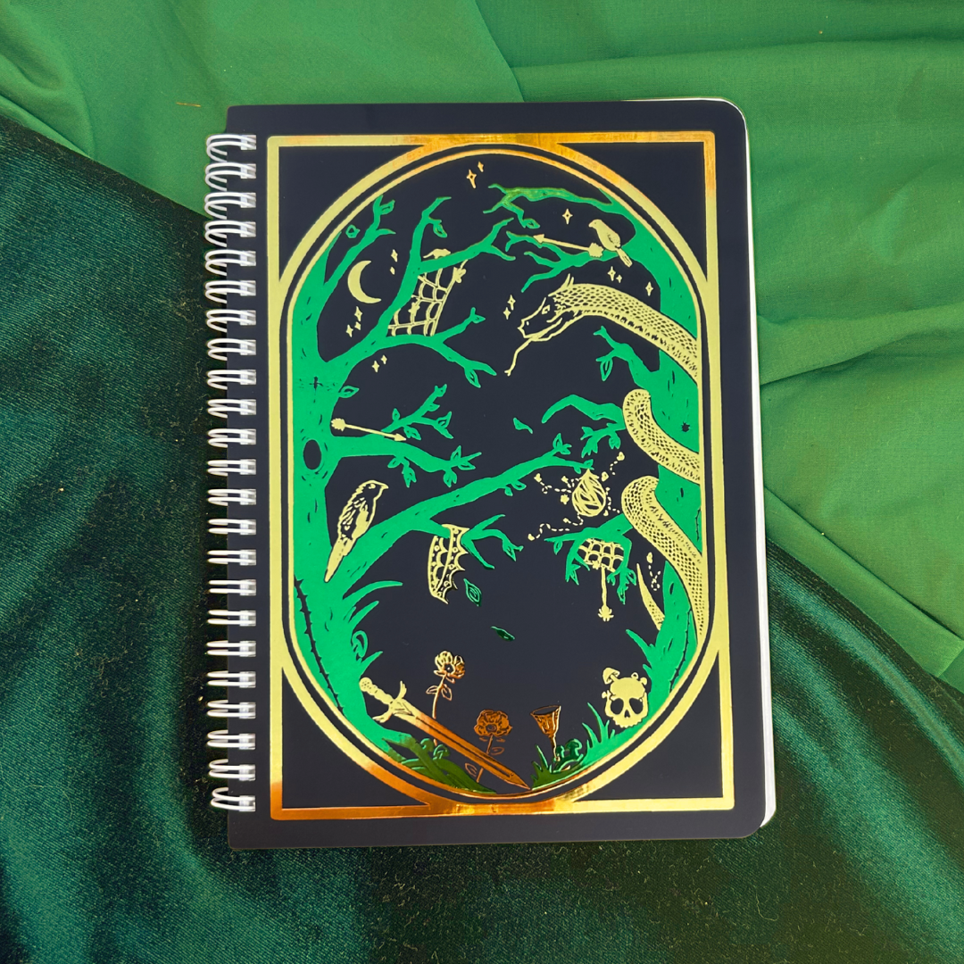 Notebook with decorative cover featuring green and gold designs on a green fabric background