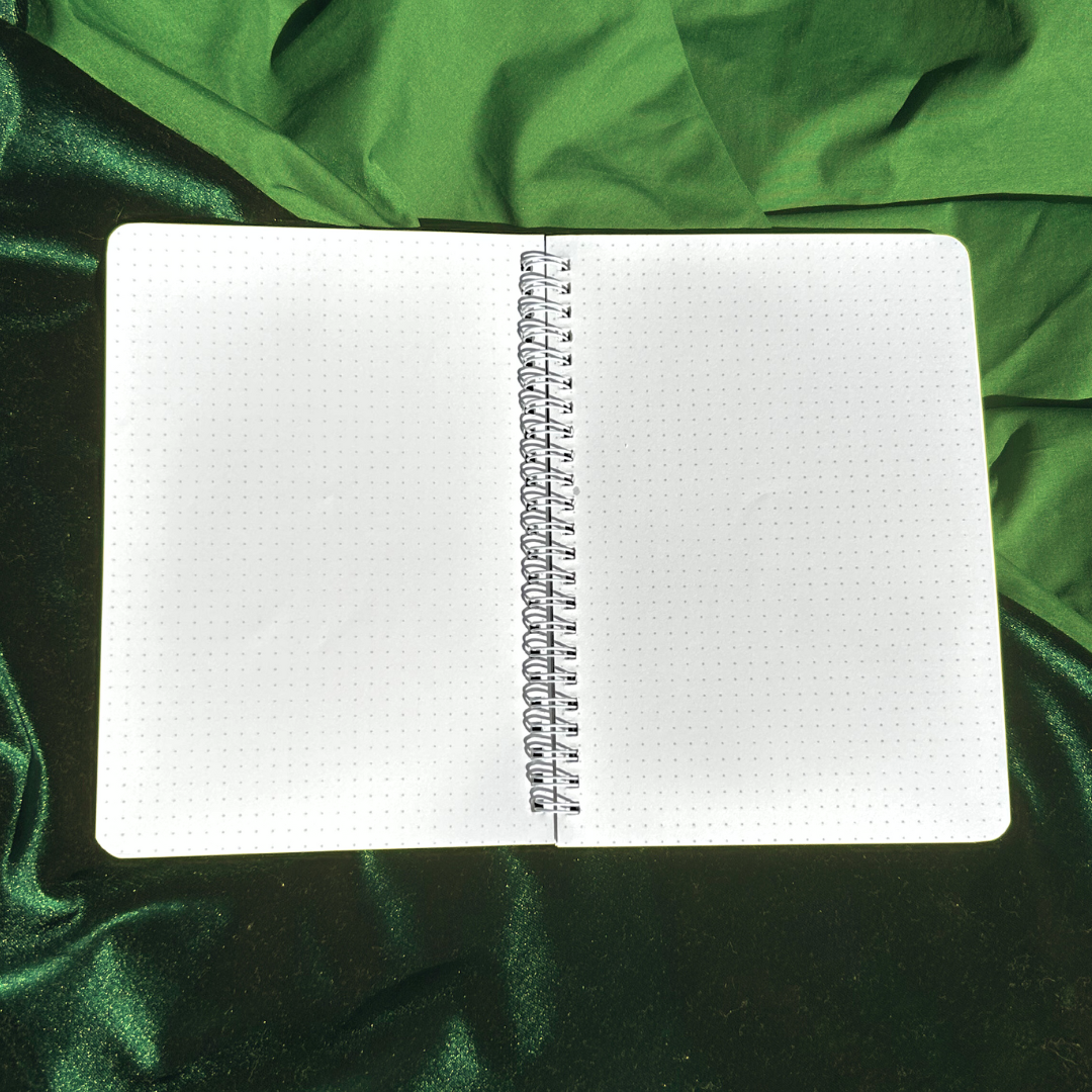 Open notebook with grid paper on a green fabric background