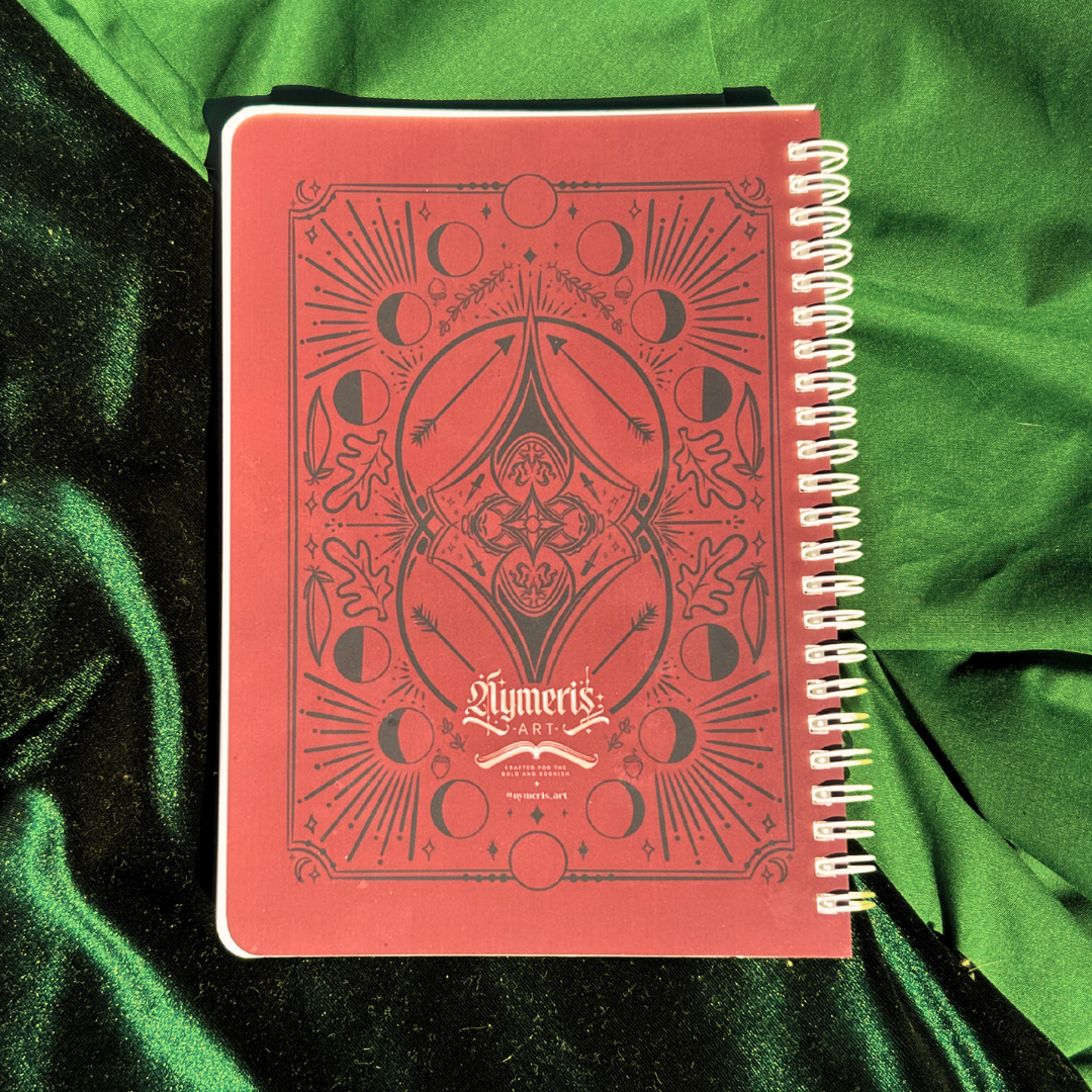Red notebook with intricate design on a green fabric background