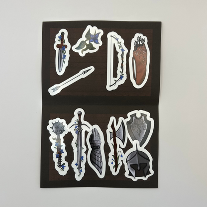 Sheet of fantasy-themed stickers featuring weapons and armor on a black background.