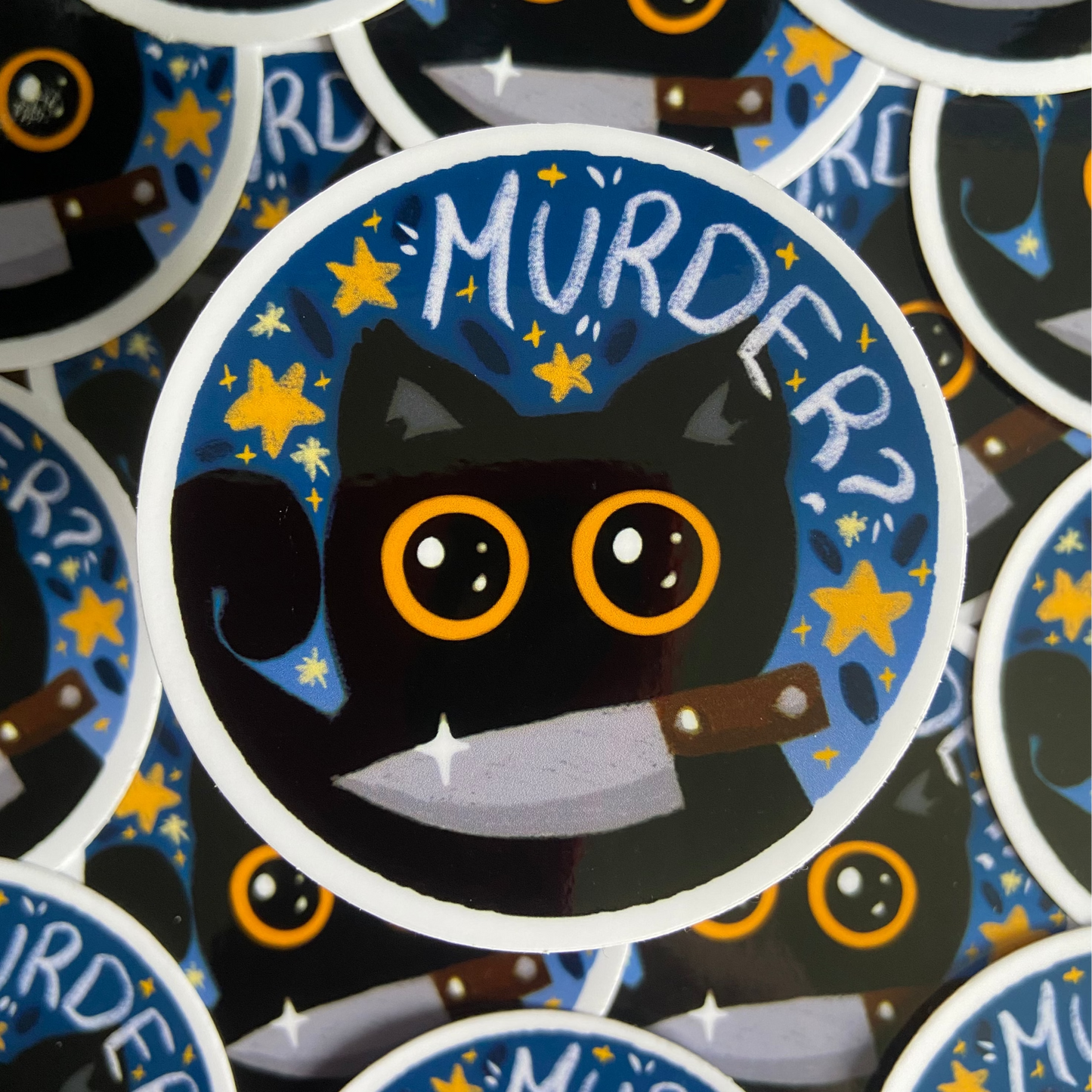 Sticker with a black cat, knife, and 'MURDER?' text on a blue background.