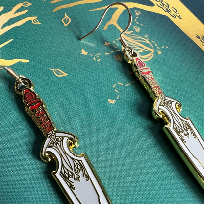 Decorative dagger-shaped earrings on a green background with gold accents.